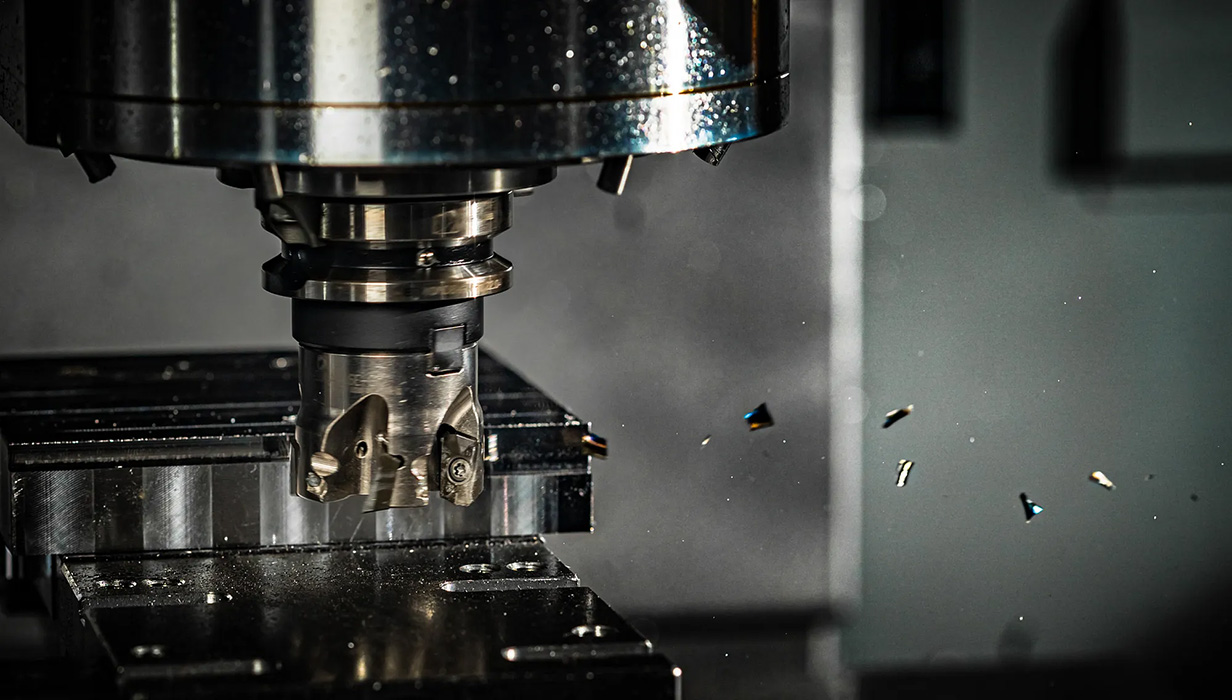 A close-up of a CNC machine tool cutting into a metal piece.